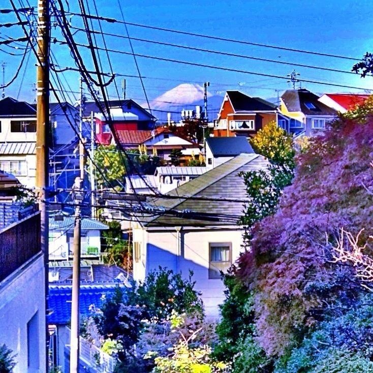 VIEW OF HOUSES AGAINST BLUE SKY AND CLOUDS