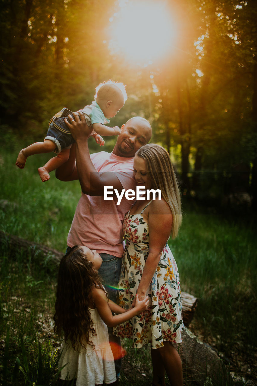 Vertical portrait of biracial family looking at each other