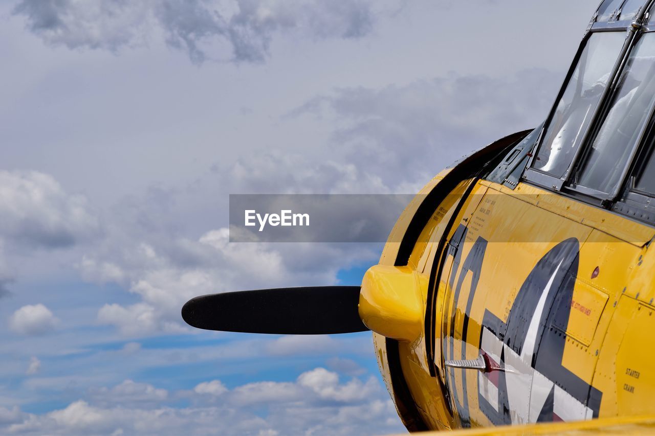 CLOSE-UP OF YELLOW TRUCK AGAINST SKY