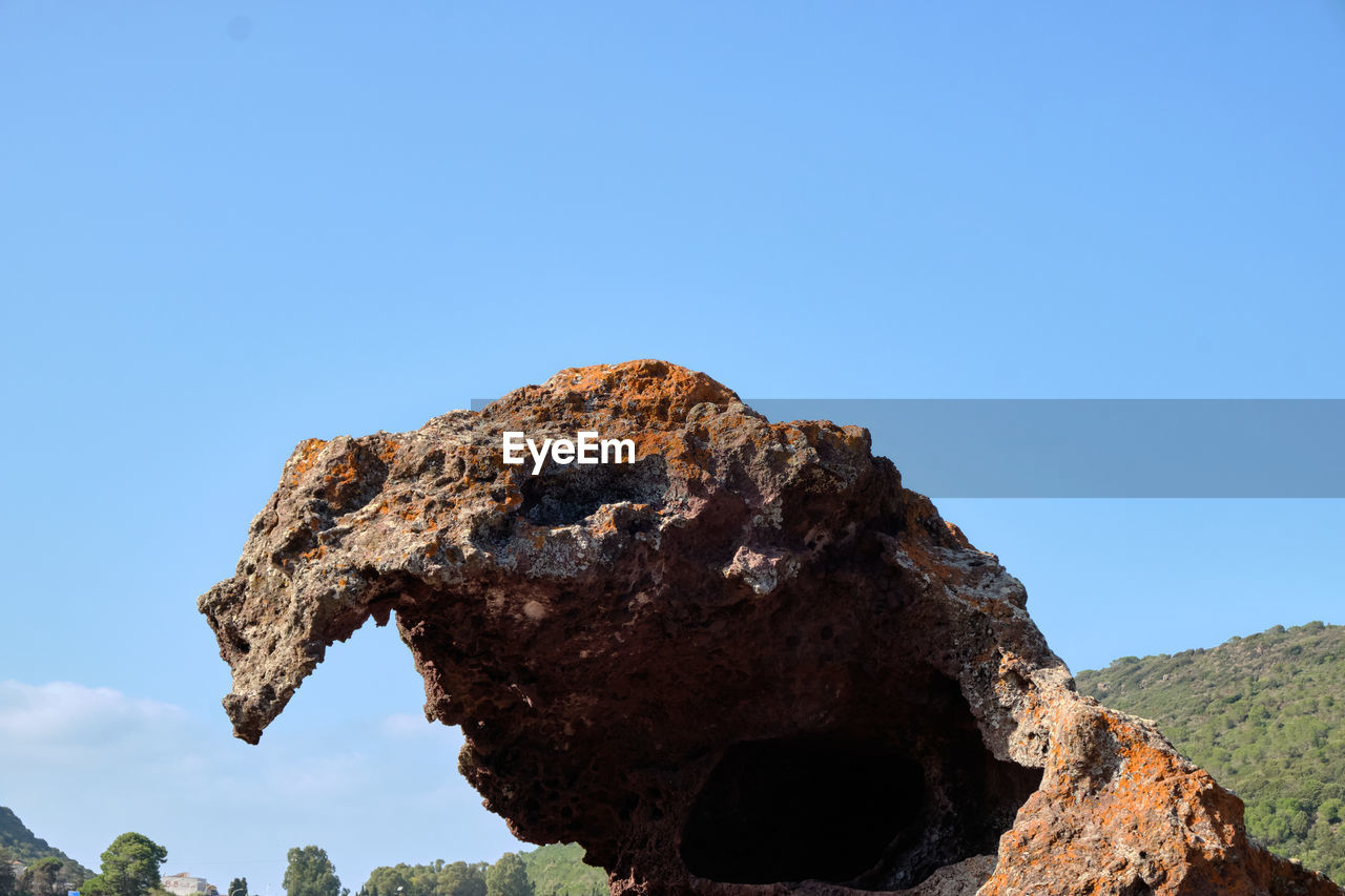 LOW ANGLE VIEW OF ROCK AGAINST CLEAR BLUE SKY