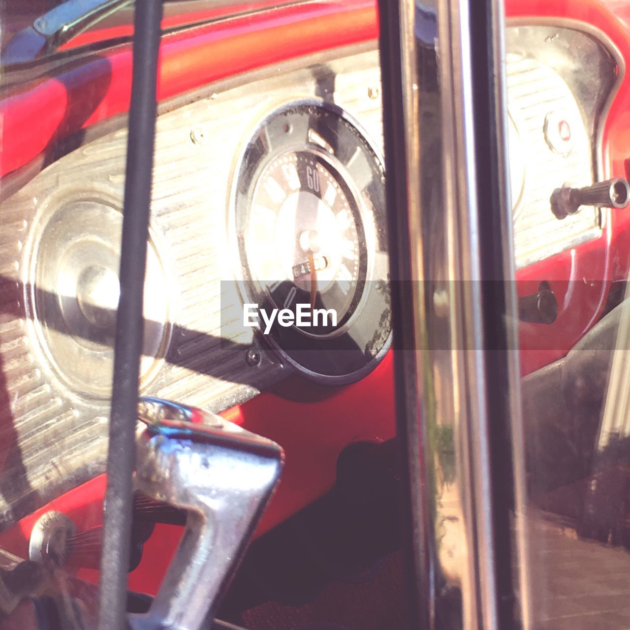 CLOSE-UP OF RED VINTAGE CAR ON BUS