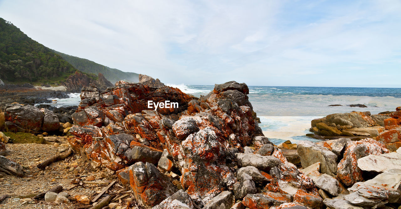 ROCKS ON SHORE AGAINST SKY