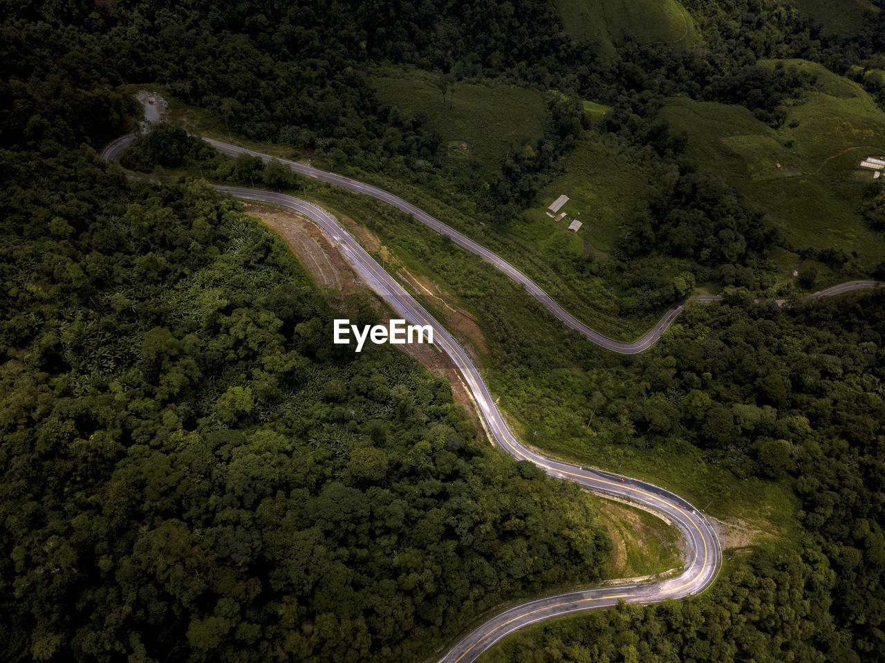 Aerial view of countryside road on the lush greenery tropical rain forest mountain landscape