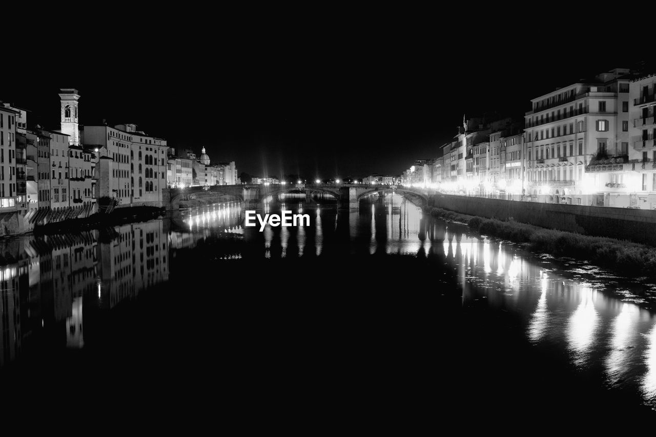 ILLUMINATED BUILDINGS WITH WATERFRONT AT NIGHT