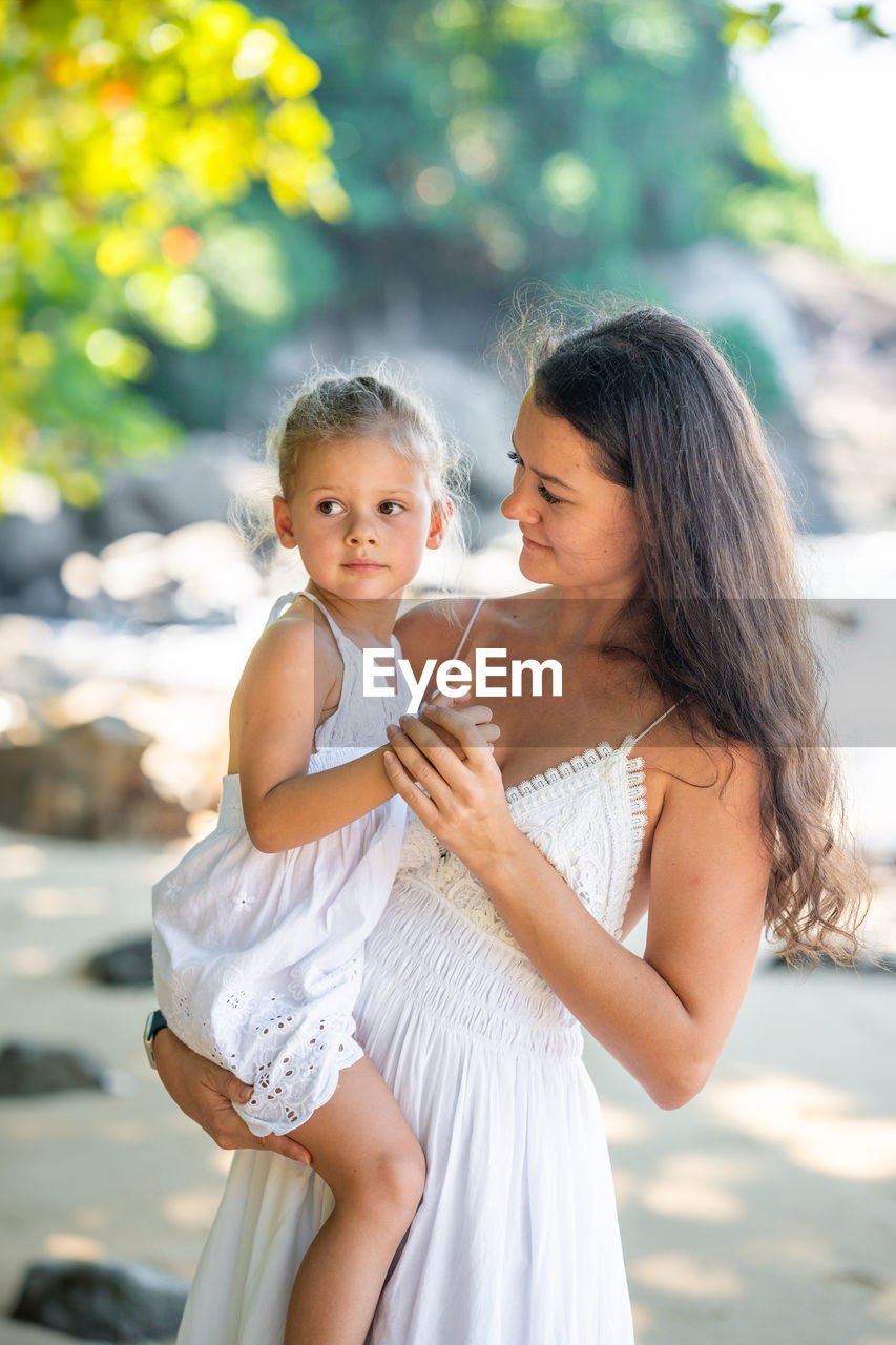 side view of mother and daughter at home