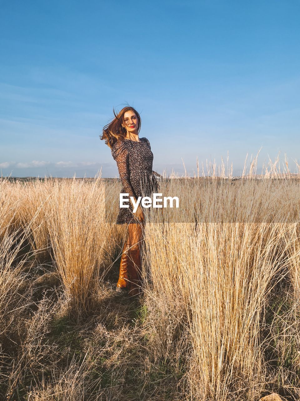 Full length of woman standing on field against sky