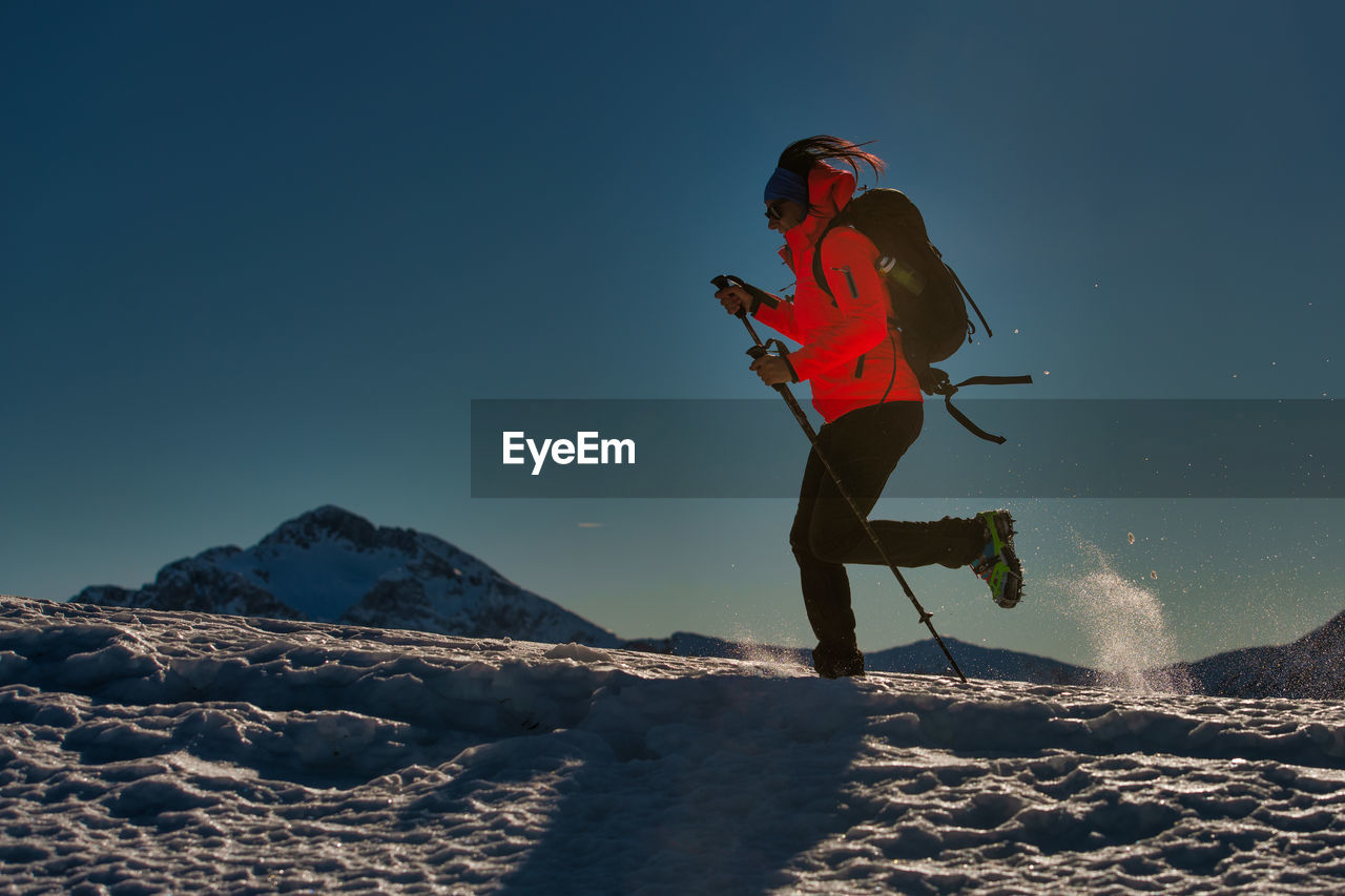 WOMAN WITH UMBRELLA ON MOUNTAIN DURING WINTER