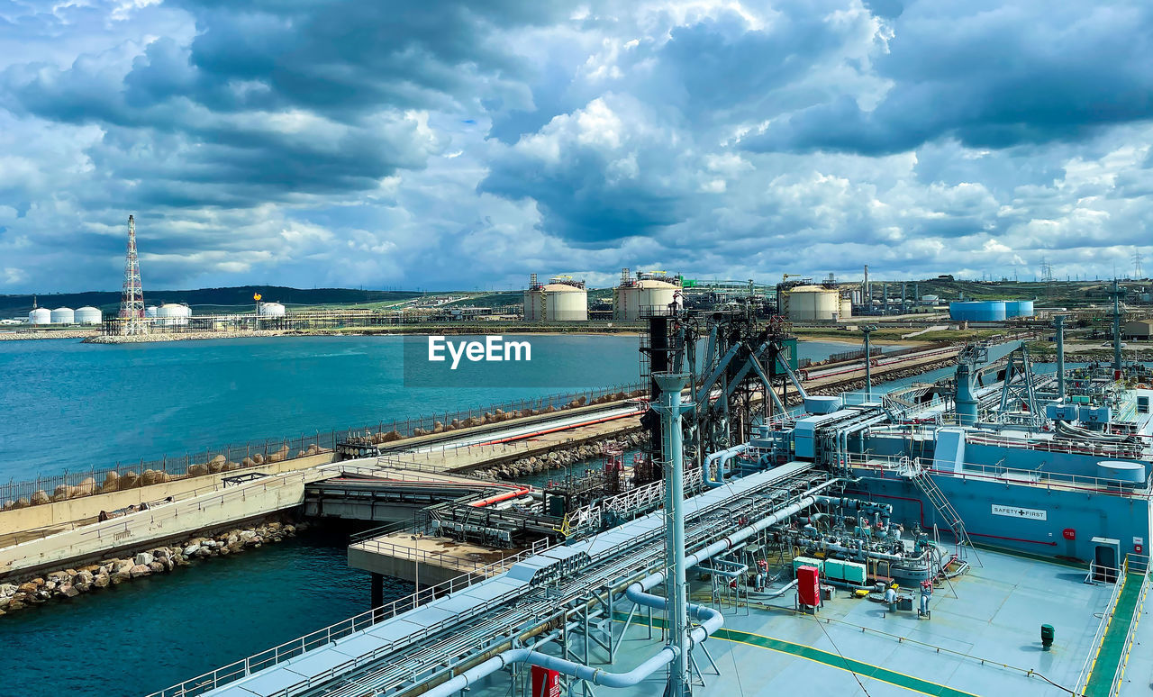 Lpg cargo ship docked in the port. view from the deck of the ship to the shore and gas tanks.