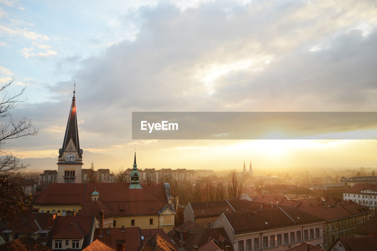 View of cityscape against cloudy sky