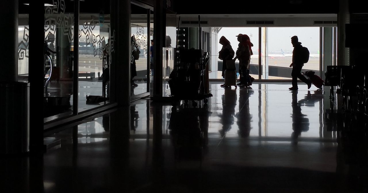 GROUP OF PEOPLE WALKING IN AIRPORT