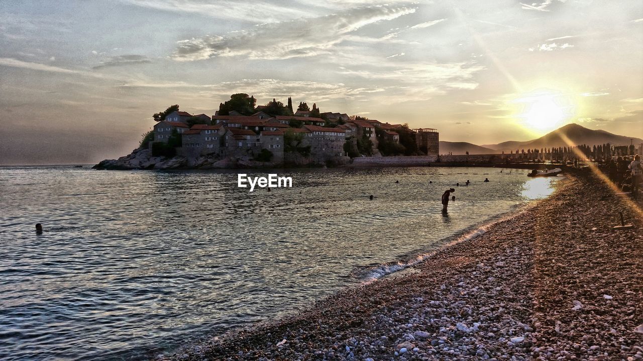 Scenic view of sveti stefan against sunset sky