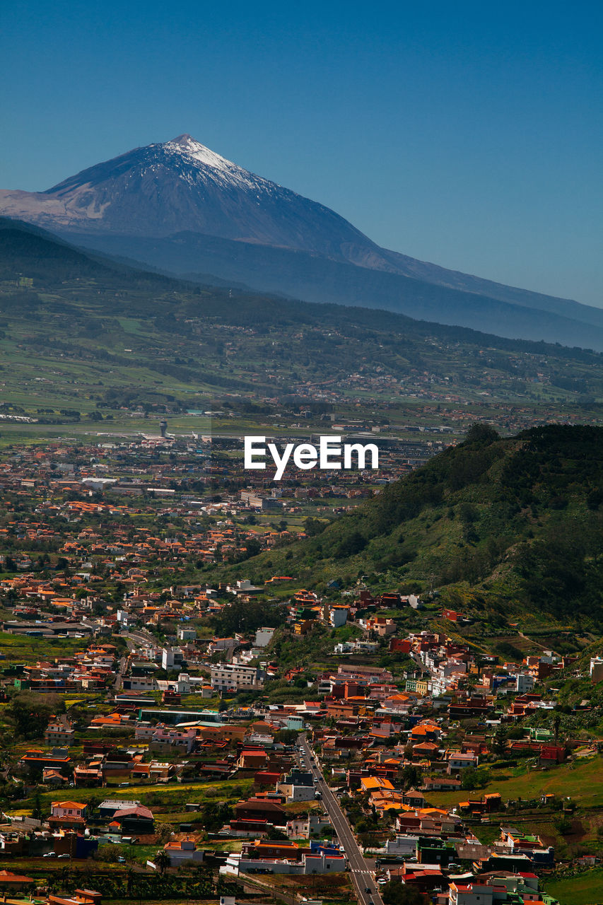 High angle view of townscape and mountain against sky