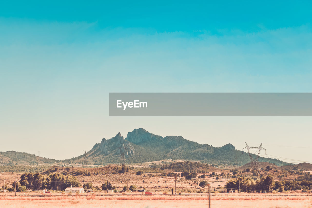 Scenic view of desert against clear blue sky