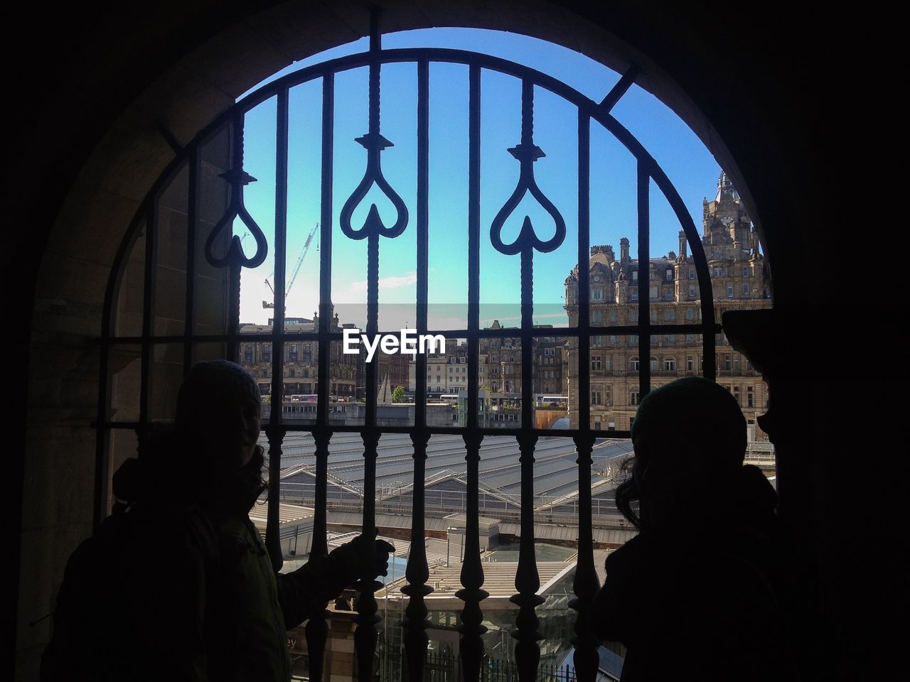Women standing by window with city in background