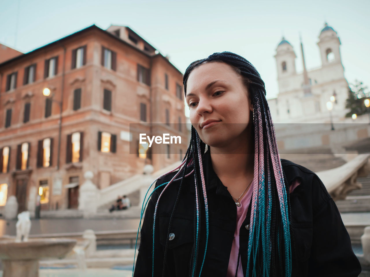 Beautiful woman standing against buildings in city