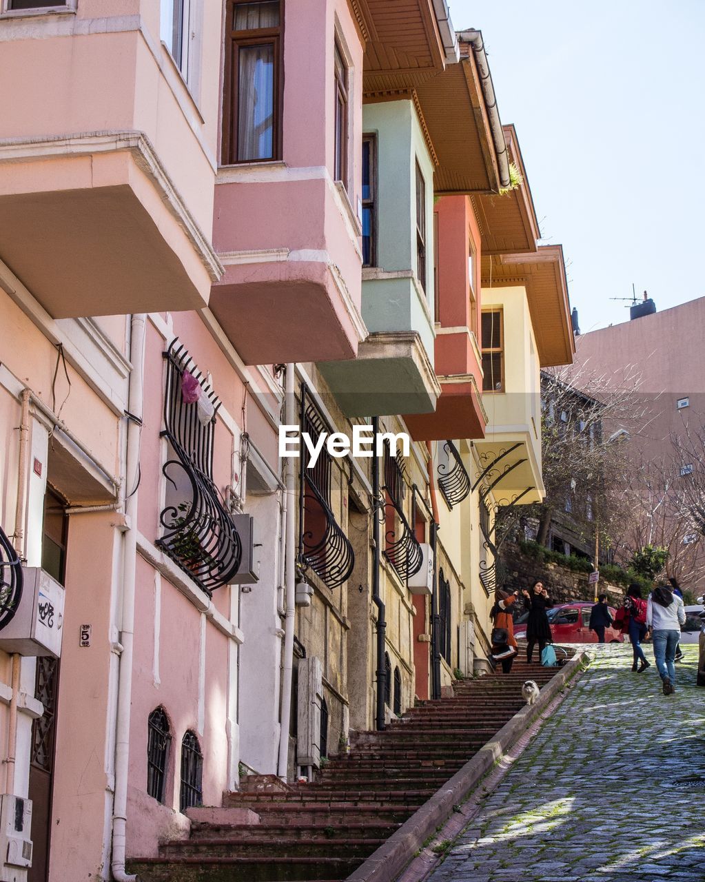 PEOPLE ON STREET AMIDST BUILDINGS AGAINST SKY