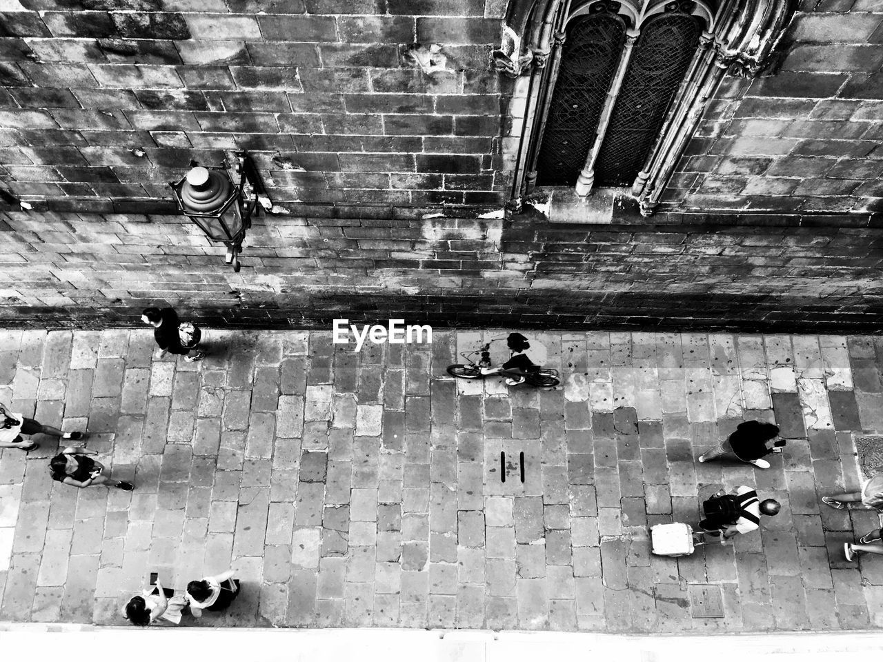 HIGH ANGLE VIEW OF PEOPLE WALKING ON COBBLESTONE STREET