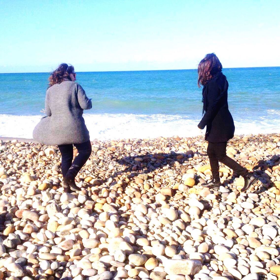 FULL LENGTH OF FRIENDS STANDING ON BEACH