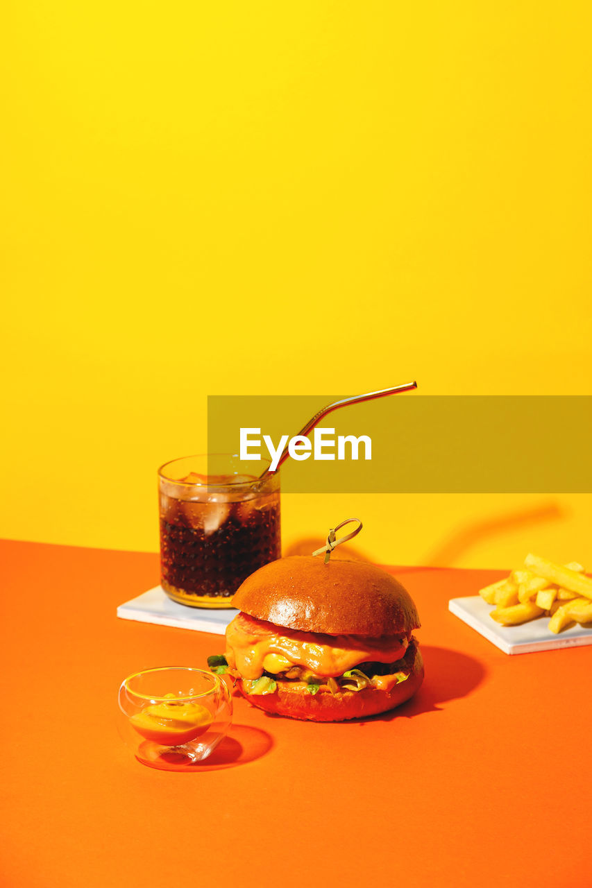 Close-up of drink on table against yellow background