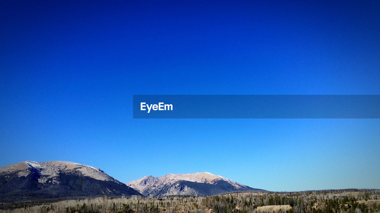 Scenic view of mountains against clear blue sky