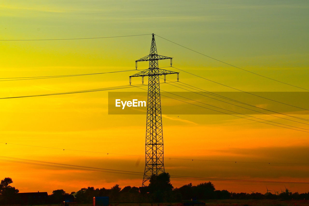 Low angle view of silhouette electricity pylon against romantic sky during sunset in the evening