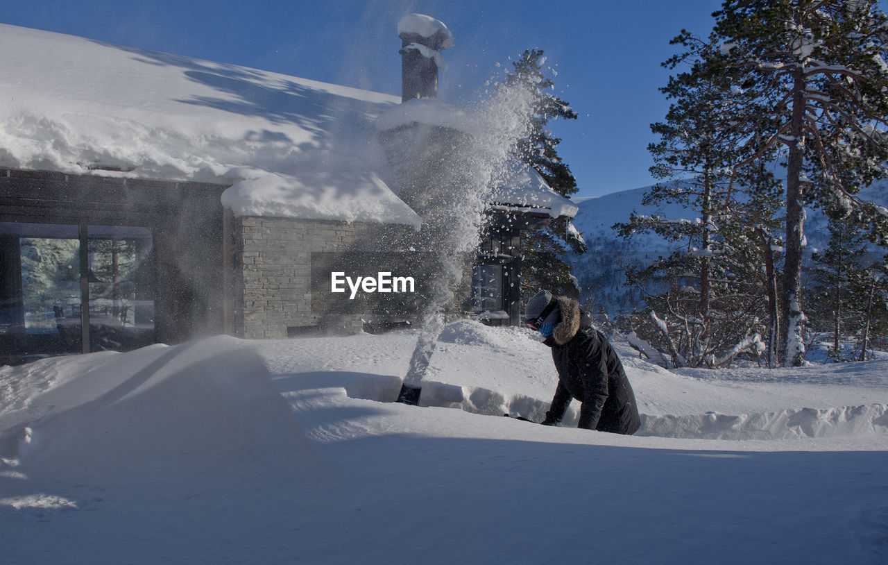 Man removing snow outside house