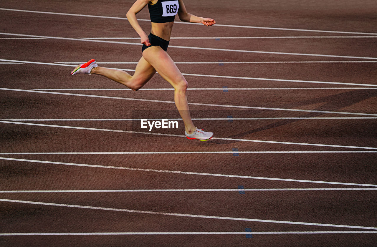 full length of young woman jumping on playing field