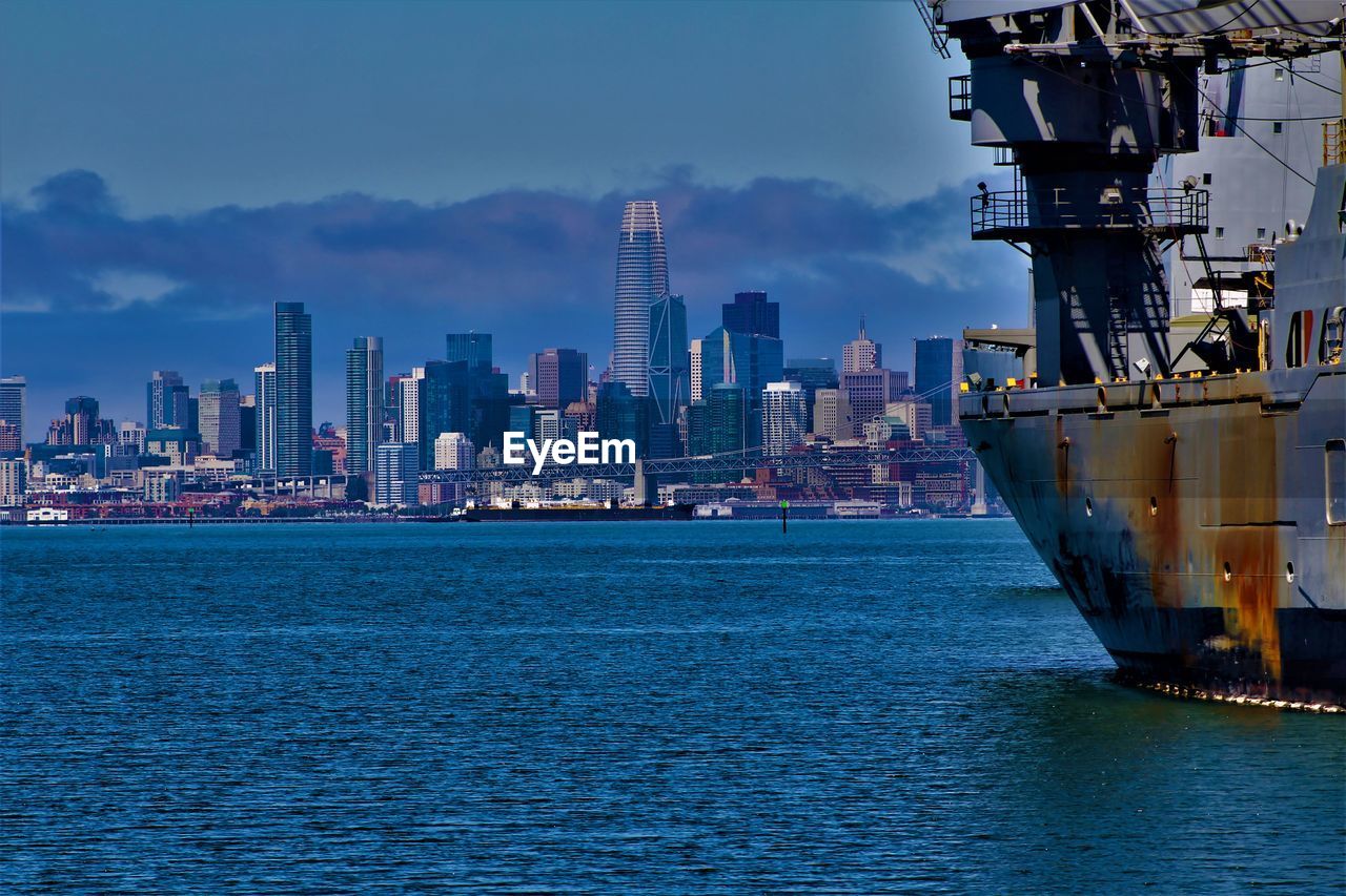 SEA BY BUILDINGS AGAINST SKY IN CITY