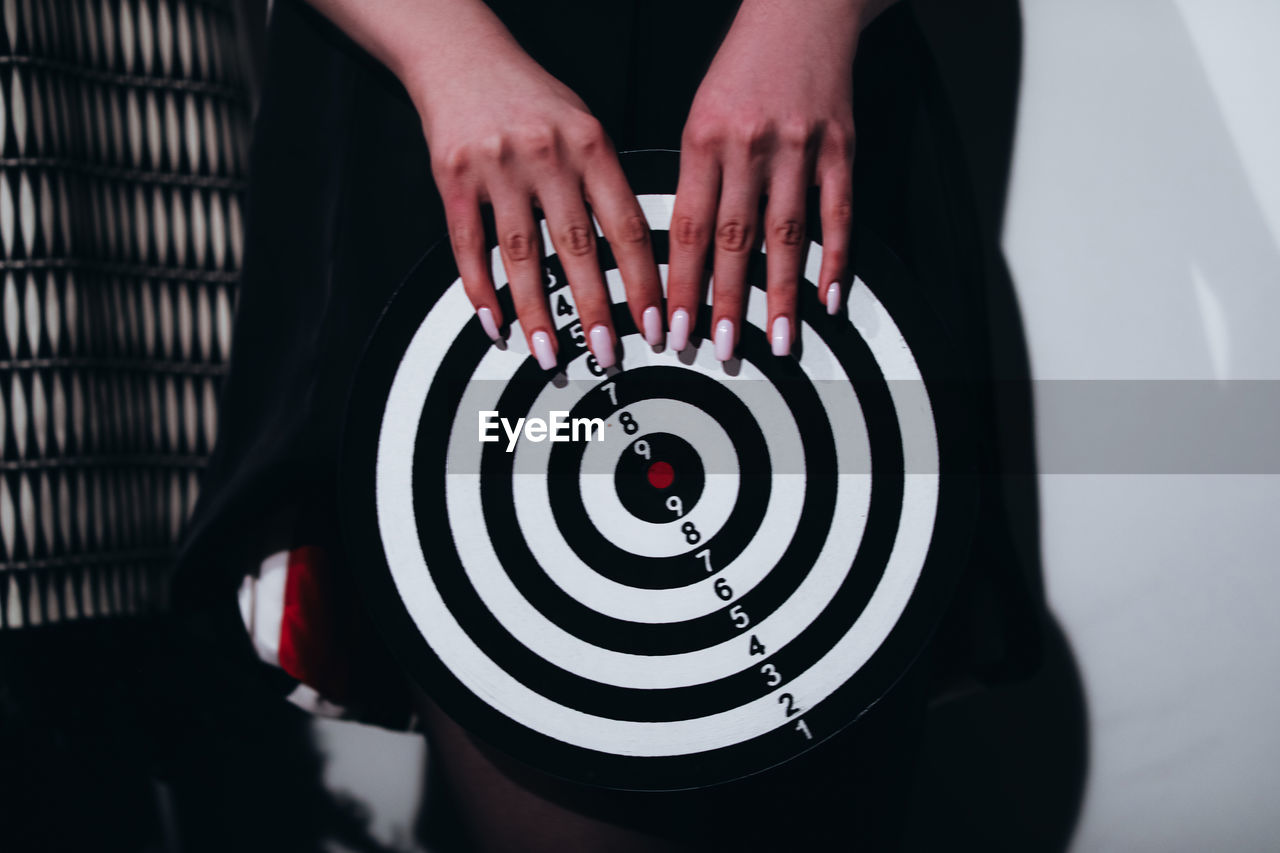 Female hands holding a dartboard