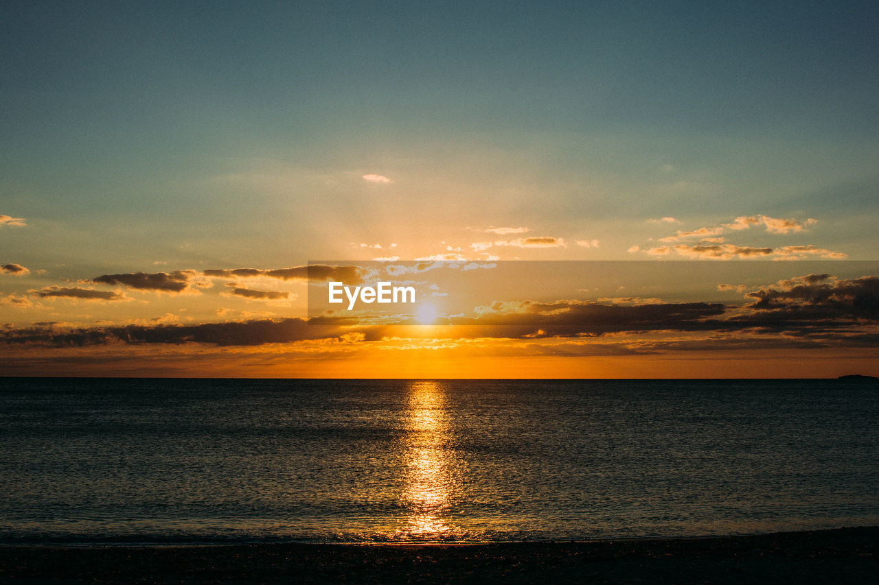 SCENIC VIEW OF SUNSET OVER SEA