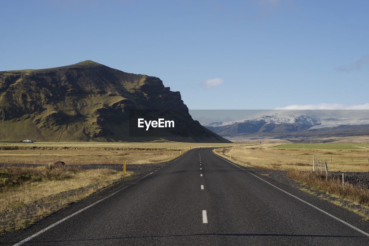 Lonely road leading towards the icelandic mountains 
