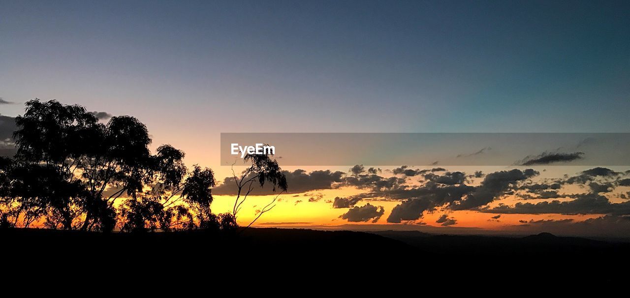 SCENIC VIEW OF SILHOUETTE LANDSCAPE AGAINST ORANGE SKY