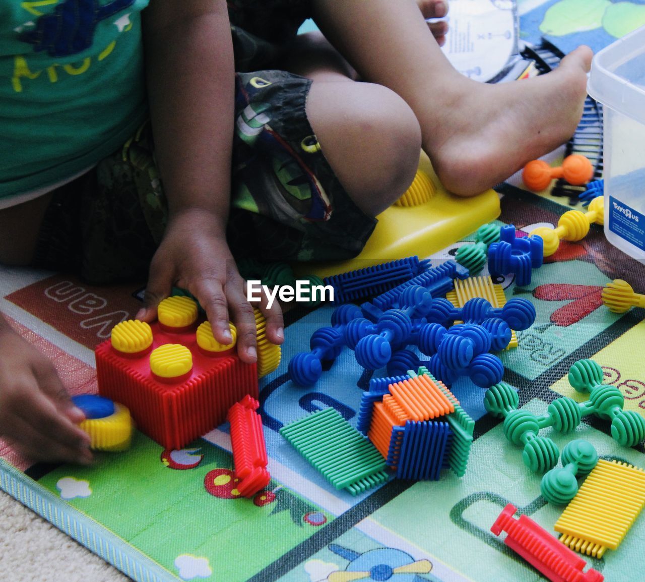 MIDSECTION OF CHILD PLAYING WITH TOY