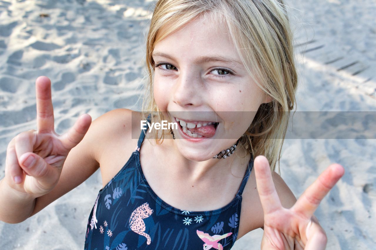 Portrait of smiling girl gesturing at beach