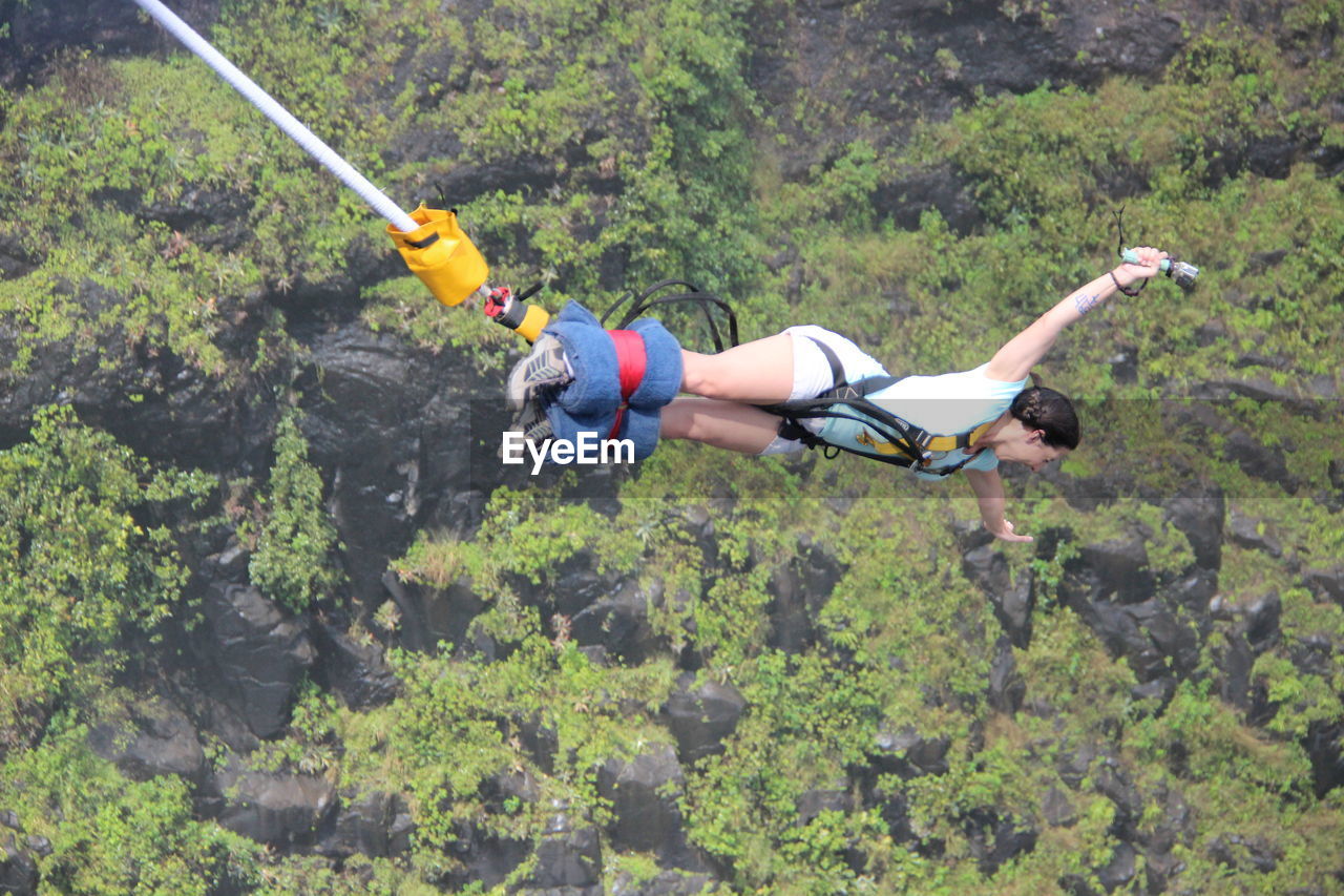 High angle view of young woman bungee jumping