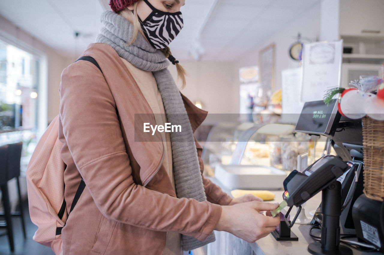 Woman with face mask paying