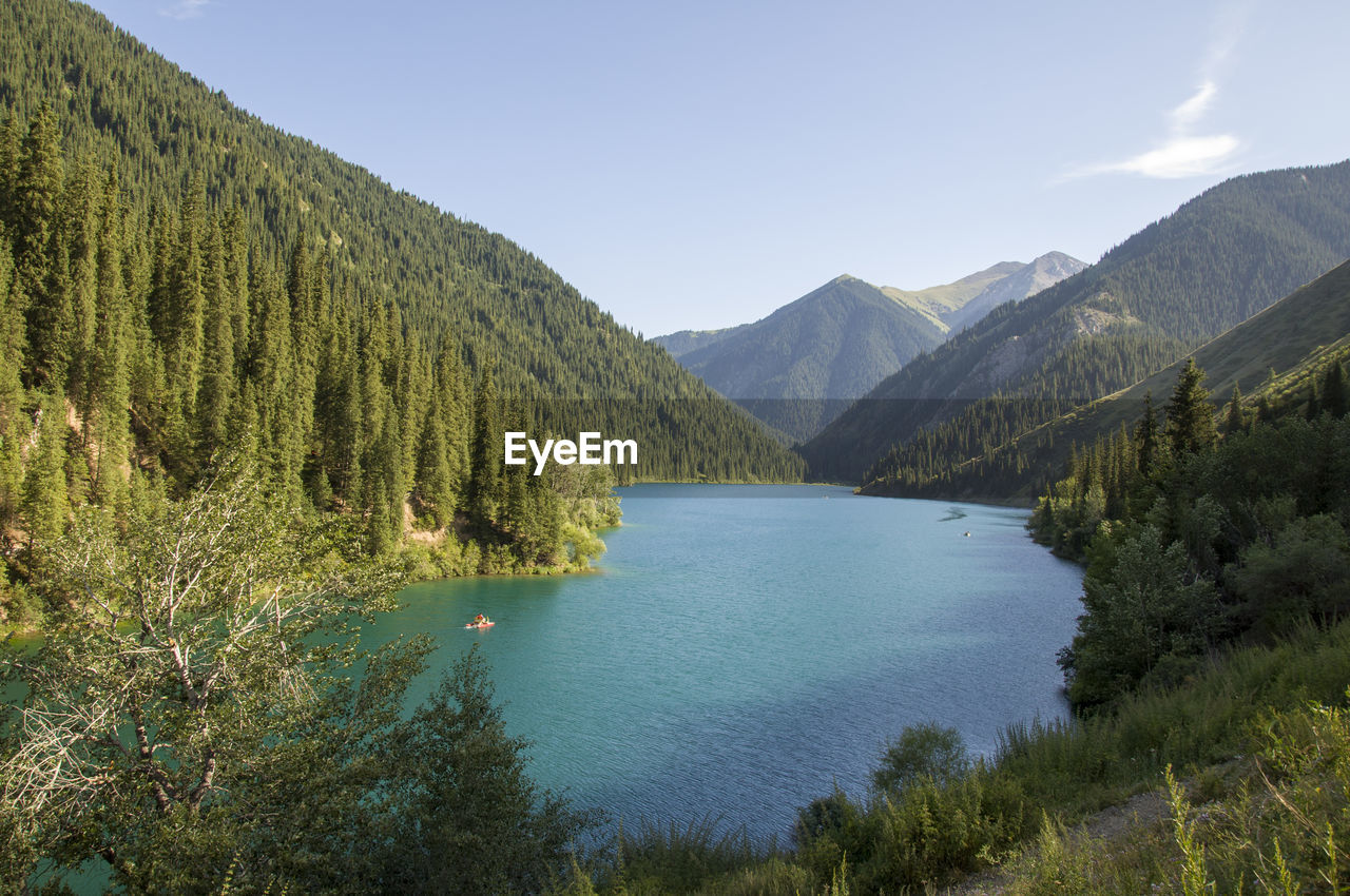 Scenic view of lake by mountains against sky