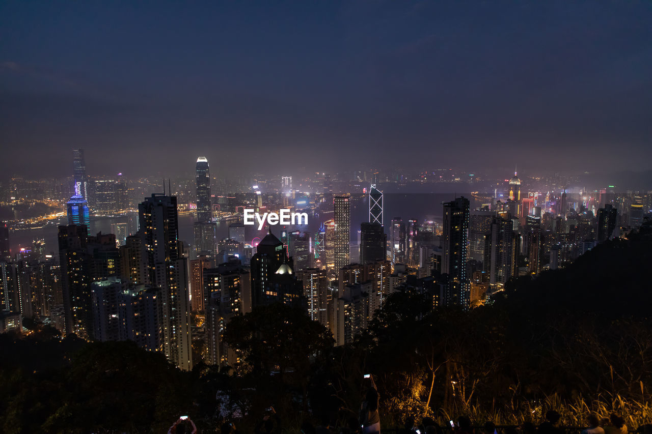 Illuminated cityscape against sky at night