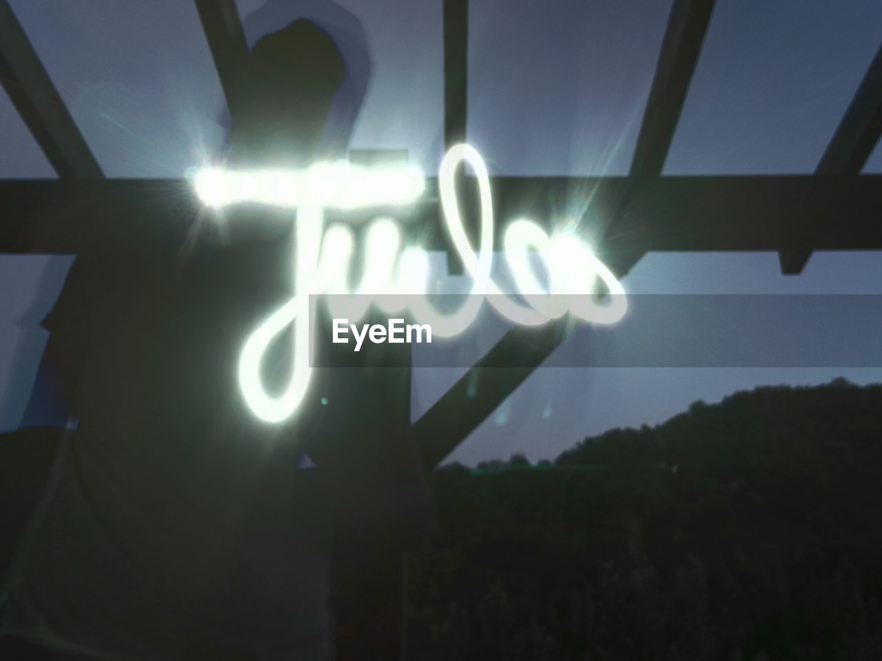 Low angle view of man with light painting at night