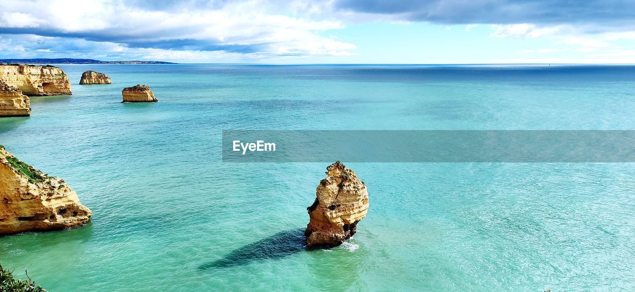 Panoramic view of rock on sea against sky