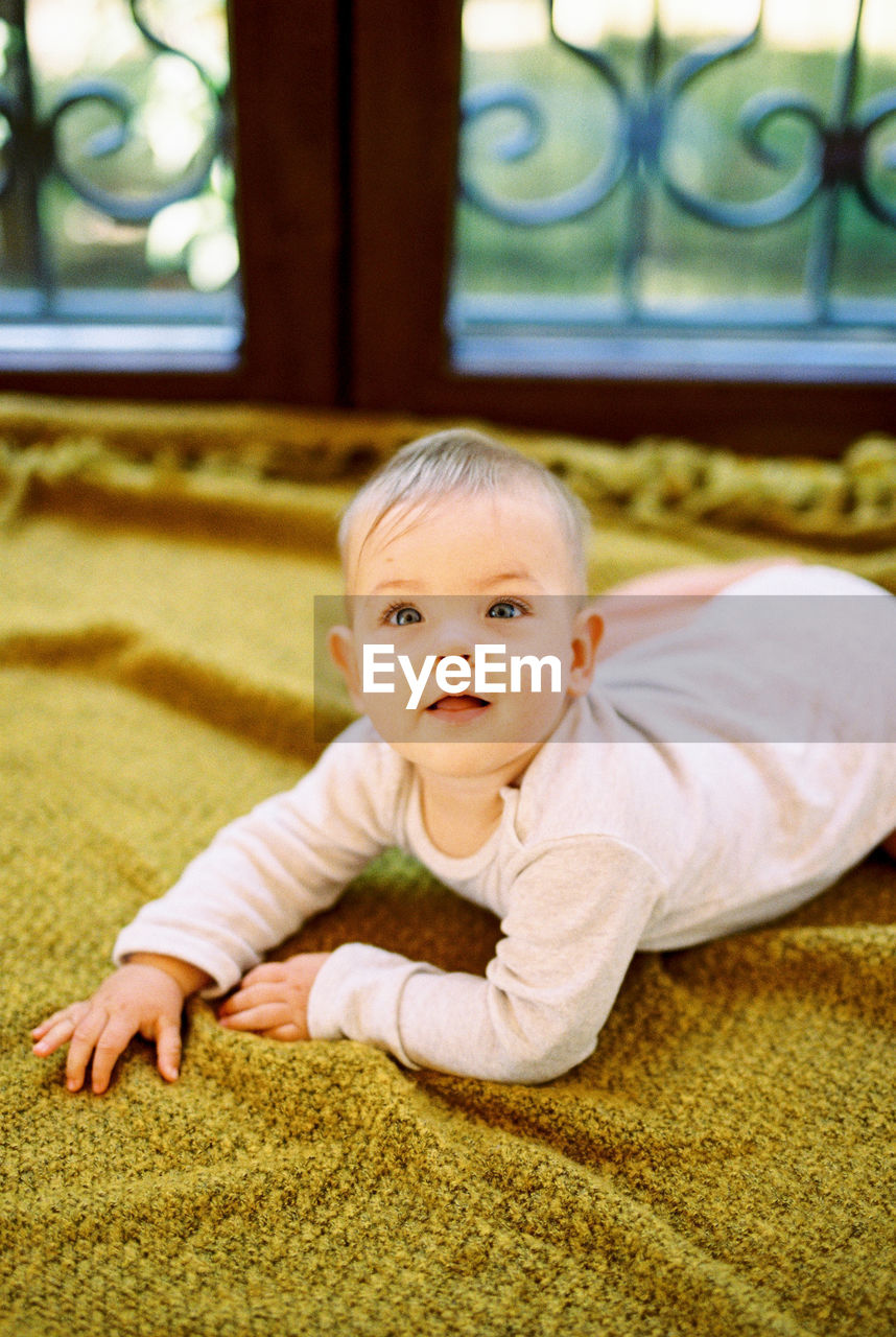 portrait of cute baby boy lying on floor