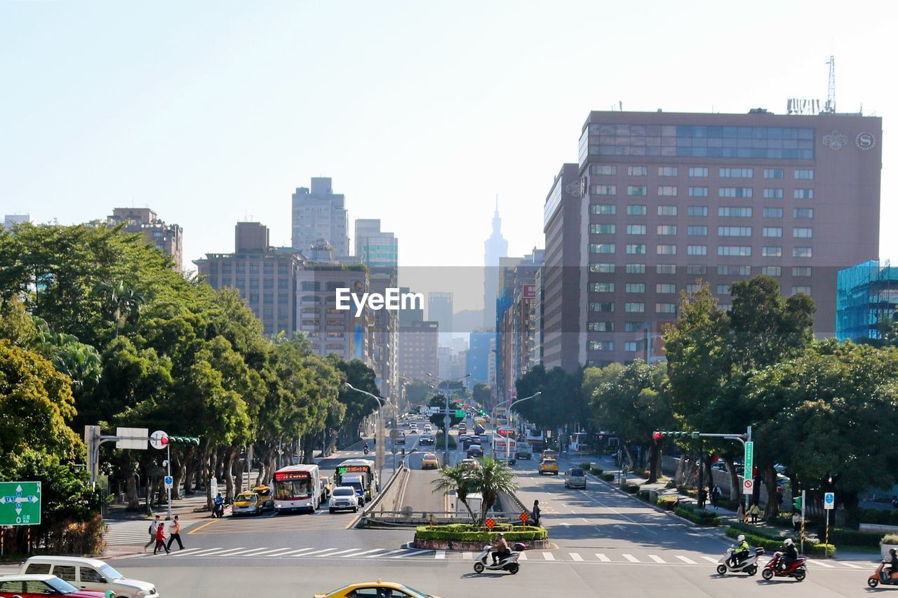 Cars on city street against clear sky