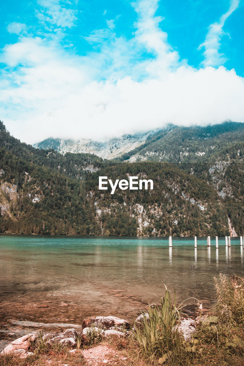 Scenic view of lake by mountains against sky