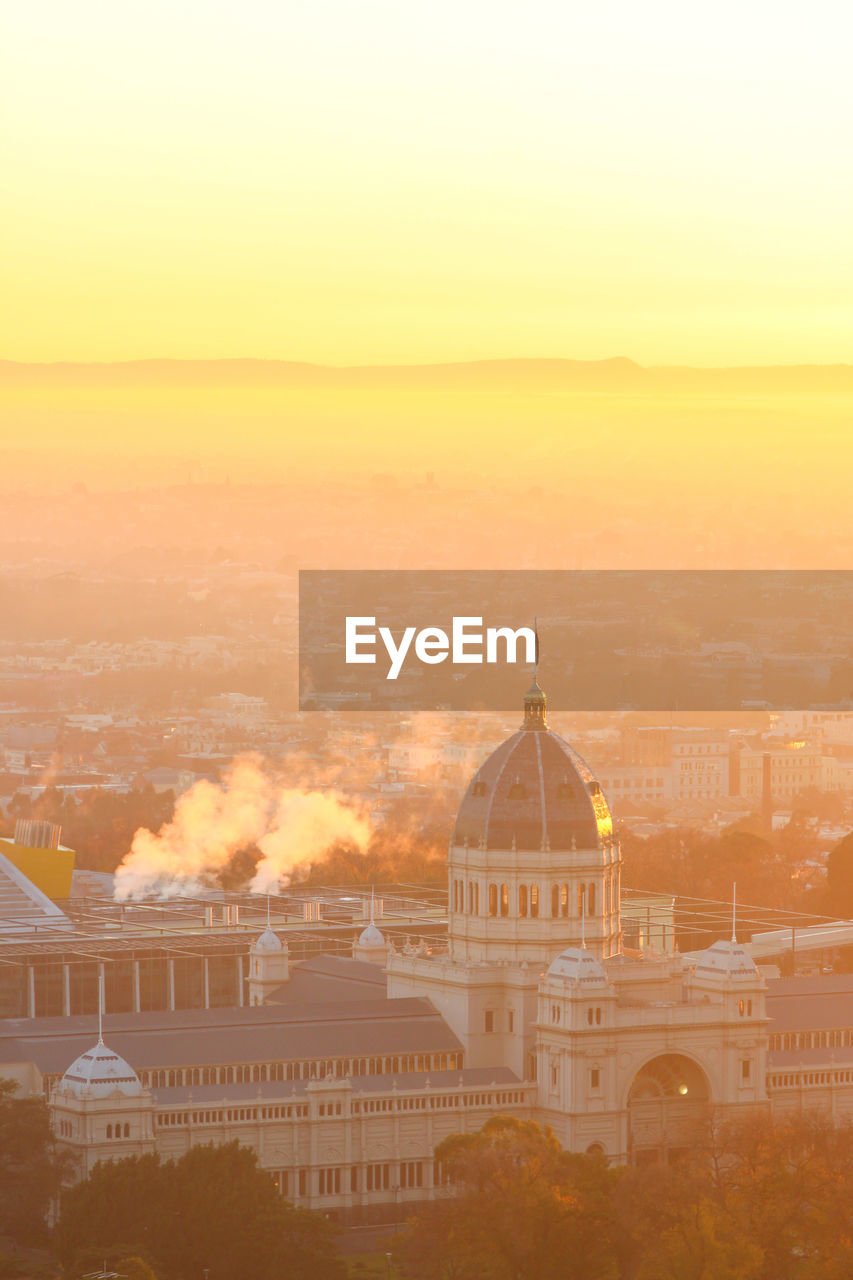 High angle view of royal exhibition hall building surrounded by fog during sunrise