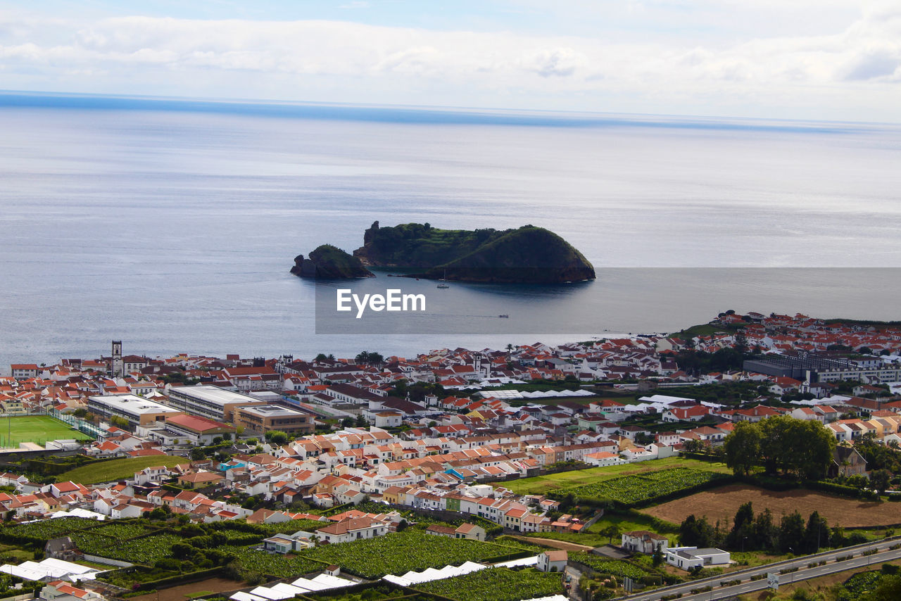 High angle view of townscape by sea against sky