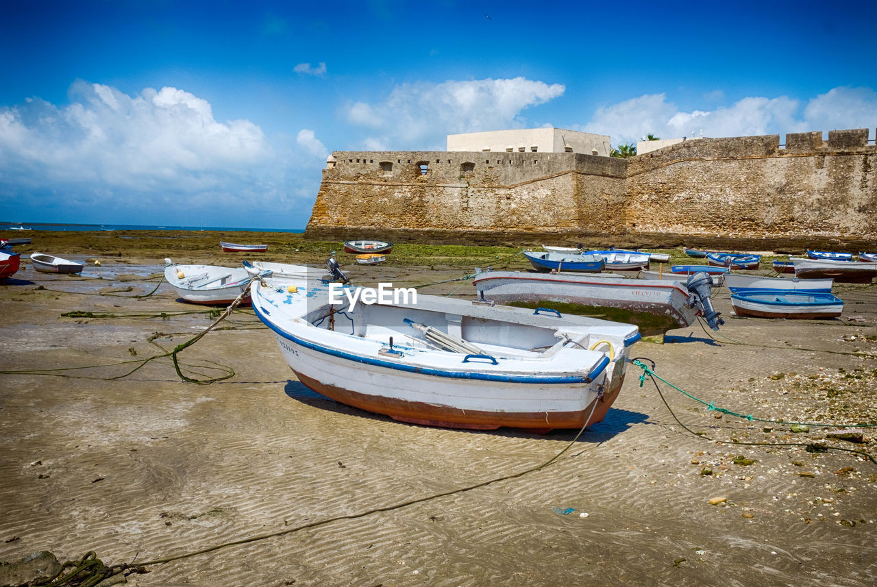 Boats moored on beach against sky