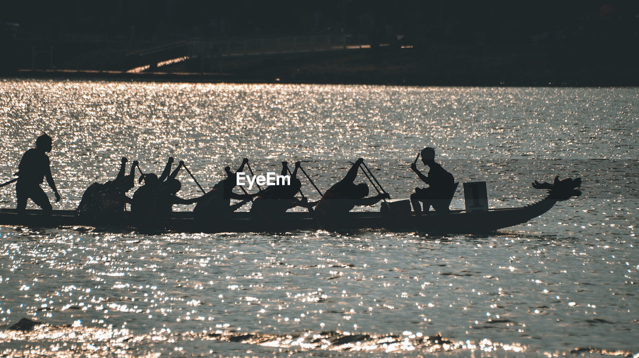 SILHOUETTE PEOPLE ON BOAT AT SEA