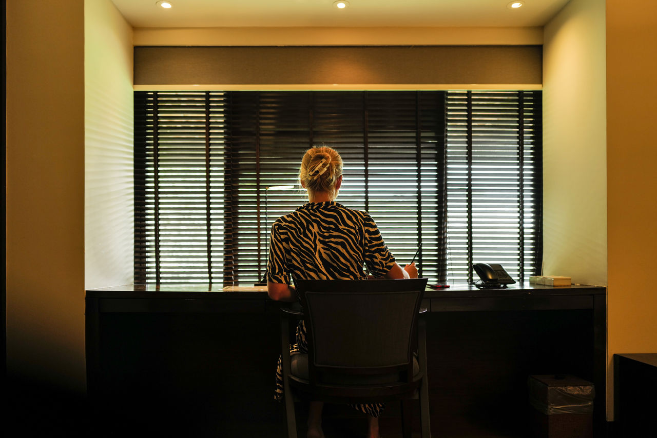 Woman sitting down next to the writing table making notes