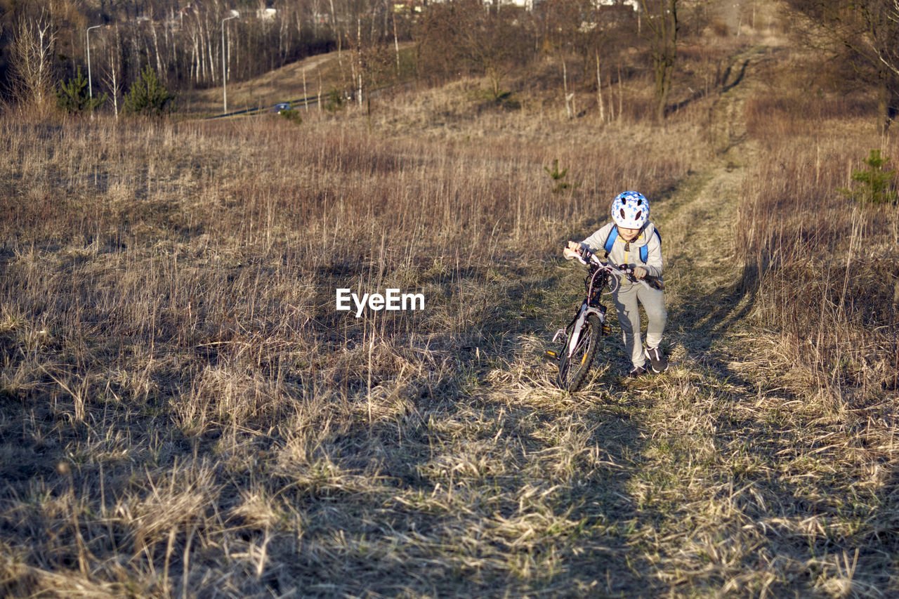 Boy riding bicycle on field