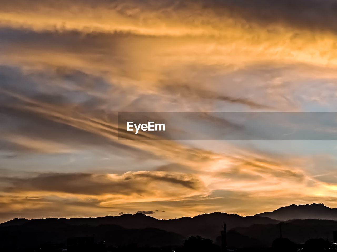 Low angle view of silhouette mountains against dramatic sky